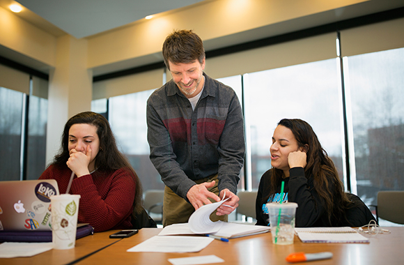 Photo of Joshua Vink and a couple students from his arts fundraising class.
