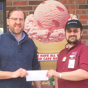 Alex Hostetter, manager of Stewart’s Shop in Potsdam, presents a check to Community Performance Series Executive Director Jason L. Dominie.